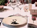 Une élégante table de mariage dressée avec des verres à pied, une assiette ornée d'un cerf, et un marque-place pour le Grand-Duc de Luxembourg.