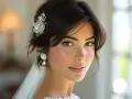 Une mariée aux cheveux courts, ornée d'une épingle scintillante et de boucles d'oreilles élégantes, rayonne de bonheur.