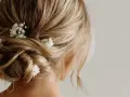 Coiffure invitée mariage boheme : un chignon flou orné de petites fleurs blanches, parfait pour une allure romantique et décontractée.