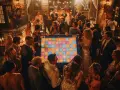 Des invités s'amusent autour d'un jeu coloré, un quizz mariage marrant, lors d'une fête animée.