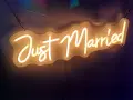 Néon "Just Married" illuminant, parfait pour une sortie de mariage dynamique, avec une musique entraînante.