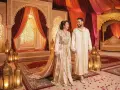 Un couple rayonnant lors d'un mariage arabe, entouré de décorations somptueuses et de lanternes dorées.