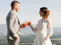 Un couple marié trinque avec des cocktails fruités, une belle quantité de soft pour un mariage en plein air.