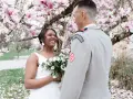 Un couple rayonnant lors de leur mariage militaire, sous un magnolia en fleurs.