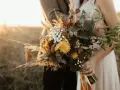 Un bouquet champêtre aux tons chauds, parfait pour des cadeaux invités mariage fait maison. Des herbes de la pampa, des fleurs jaunes et des feuilles sombres.