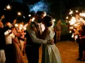 Un couple s'embrasse sous des feux de Bengale, entouré de leurs invités. Une belle idée d'animation mariage témoin pour un moment magique.