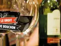 Verres de vin rouge, une bouteille et une bannière "Le Droit de Bouchon". Le prix est une question à explorer.