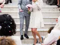 Un couple célèbre sa **danse mariage facile** sous une pluie de confettis. La mariée porte une robe blanche ornée, le marié un costume gris.