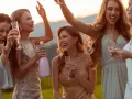 Des femmes rayonnantes célèbrent, flûtes à la main. Une robe dorée et des paillettes suggèrent que oui, peut-on porter du blanc à un mariage, si c'est pour briller !