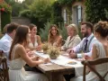 Un groupe de personnes souriantes partage un repas en plein air, profitant de jeux mariage petit comité dans un cadre champêtre.