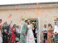 Des confettis colorés pleuvent sur les jeunes mariés qui s'embrassent. Une joyeuse tradition pour célébrer leur union.
