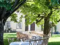 Table dressée dans un jardin luxuriant pour un quinta mariage Portugal. Ambiance champêtre sous les arbres.