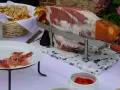 Un jambon cru entier prêt à être découpé, accompagné de pain et de fruits, pour un vin d'honneur original.