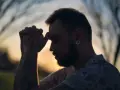 Un homme aux mains jointes, le front appuyé sur ses doigts, semble en pleine prière. Son tatouage d'ancre est visible. C'est un moment de prière des époux.