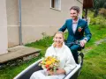 Un jeune couple souriant sur un vélo cargo, la mariée tenant un bouquet. Une idée originale pour un mariage avec un petit budget.
