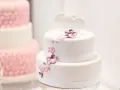 Deux pièces montées, l'une blanche décorée de cœurs et fleurs, l'autre rose texturée. Le coût d'une pièce montée peut varier.