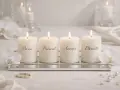 Quatre bougies allumées symbolisant le rituel des bougies mariage : Passé, Présent, Avenir, Éternité. Ornées d'orchidées blanches et d'alliances.