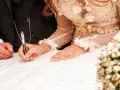 La mariée signe l'acte de mariage, un moment clé de la tradition mariage français. La bague au doigt symbolise leur union.