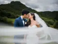 Un couple s'embrasse, le voile de la mariée flottant au vent. Une scène romantique qui donne envie de savoir comment organiser un mariage.