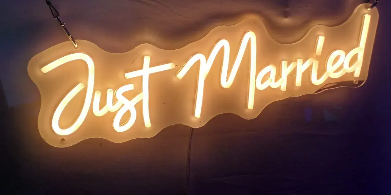 Néon "Just Married" illuminant, parfait pour une sortie de mariage dynamique, avec une musique entraînante.
