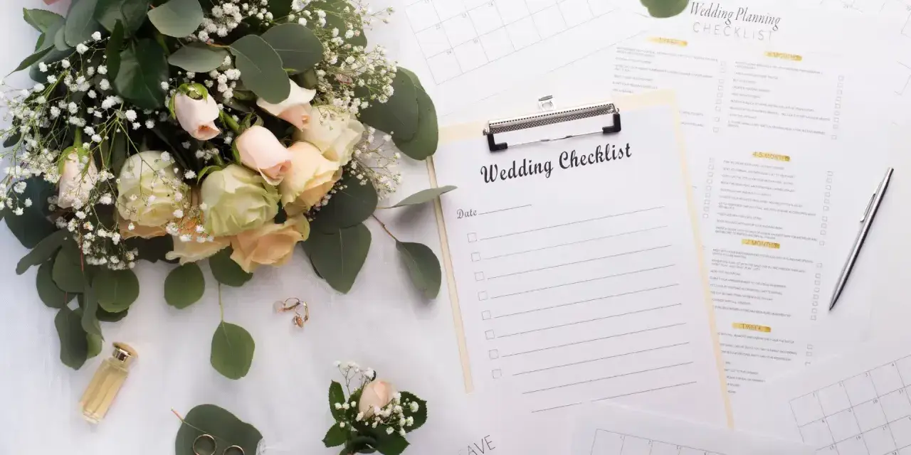 Un bouquet de roses, des alliances et une liste de mariage pour organiser son mariage soi-même.