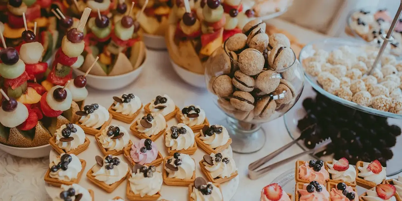 Le lendemain de mariage, un buffet de douceurs : brochettes de fruits, petits gâteaux à la crème et aux fruits, et biscuits gourmands.