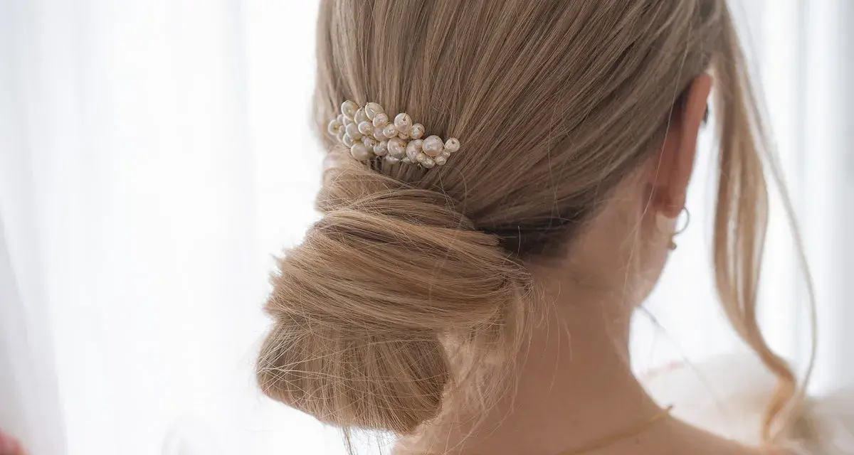 Chignon mariage flou orné d'un peigne de perles. Une coiffure élégante pour le grand jour.