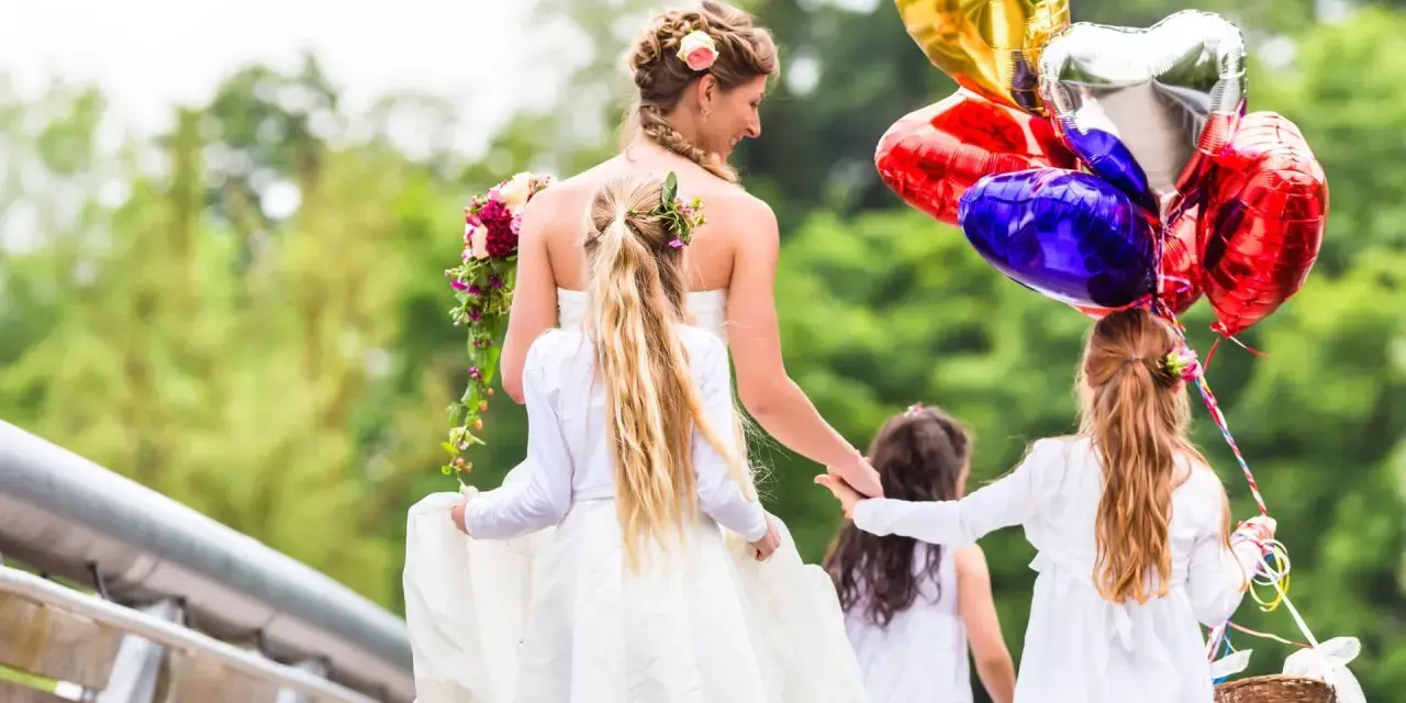 Mariée et enfants d'honneur, joyeux jeux d'enfants pour un mariage, avec des ballons en forme de cœur.