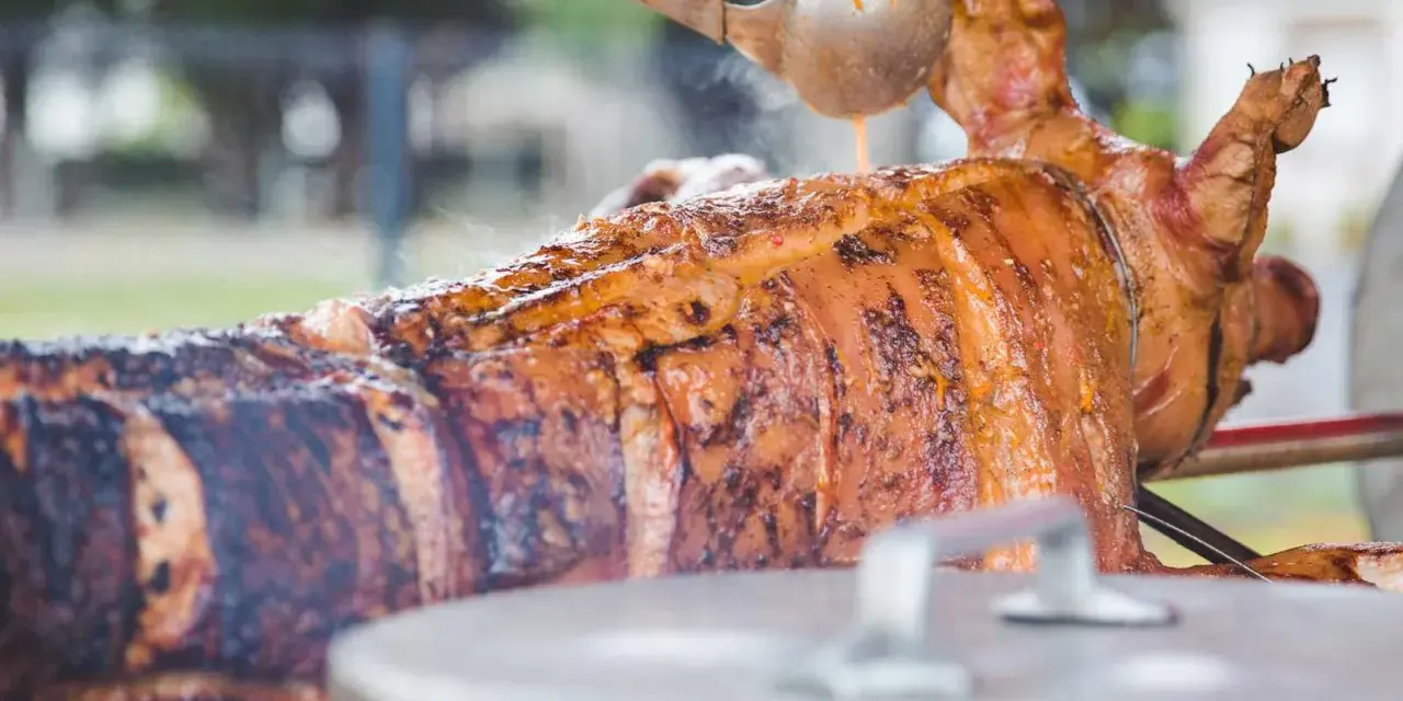 Un cochon à la broche doré et juteux, arrosé d'une sauce savoureuse. Un accompagnement parfait pour une fête mémorable.