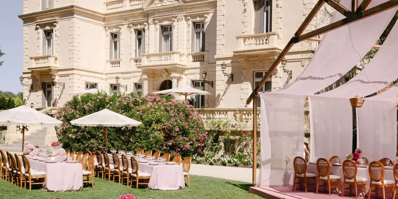 Magnifique **organisation cérémonie laïque** dans un jardin, avec tables dressées et château en arrière-plan.