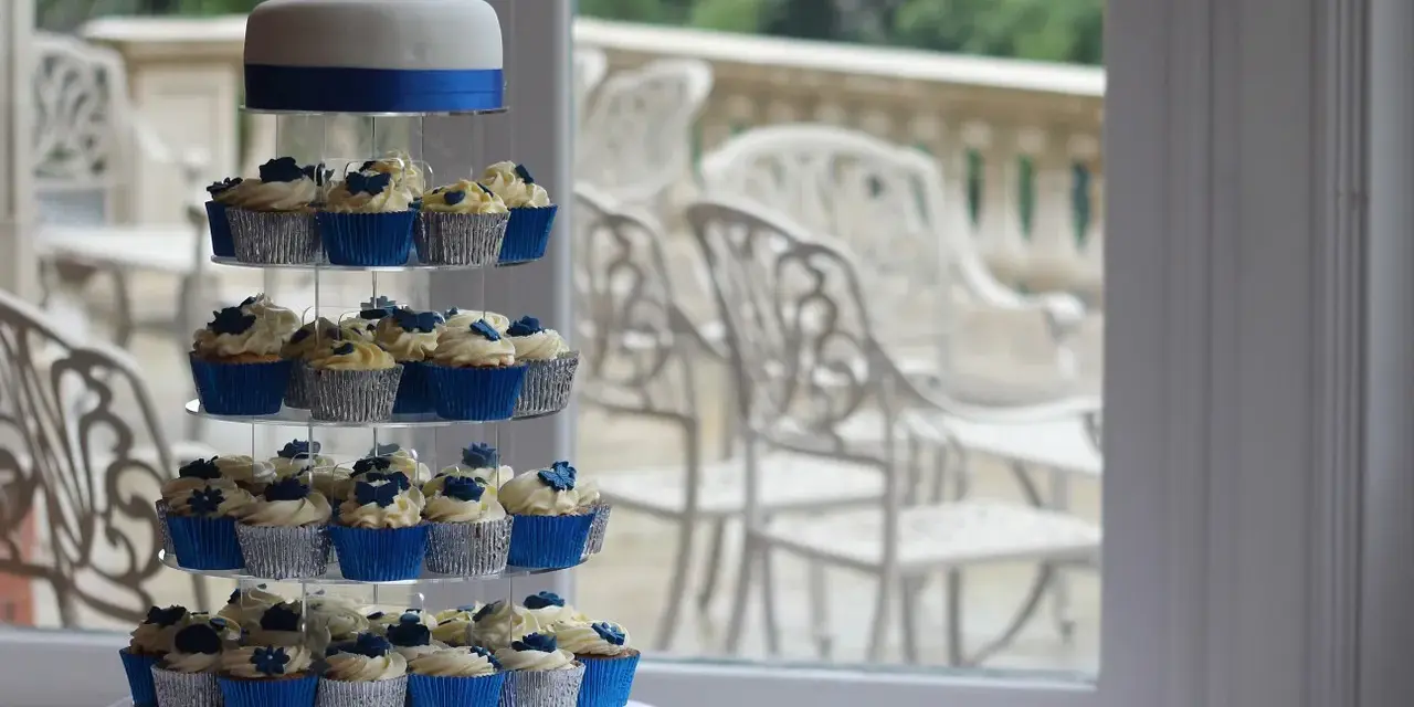 Magnifique pièce montée de cupcakes bleus et blancs, décorée de roses en sucre.