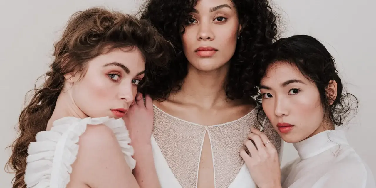 Trois femmes aux visages lumineux, prêtes pour un soin visage avant mariage. Leur peau est radieuse, leurs regards doux.