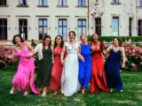 Un groupe de femmes rit joyeusement devant un château. La mariée en blanc est entourée de ses demoiselles d'honneur en robes colorées. La différence entre témoin et demoiselle d'honneur est subtile, mais leur complicité est évidente.