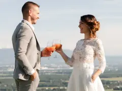 Un couple marié trinque avec des cocktails fruités, une belle quantité de soft pour un mariage en plein air.
