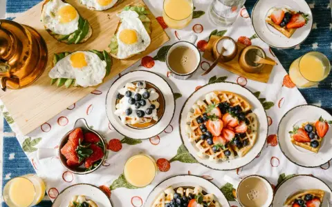 Un délicieux brunch de mariage : gaufres aux fruits, toasts avocat-œuf, jus d'orange et café. Une idée parfaite pour célébrer !