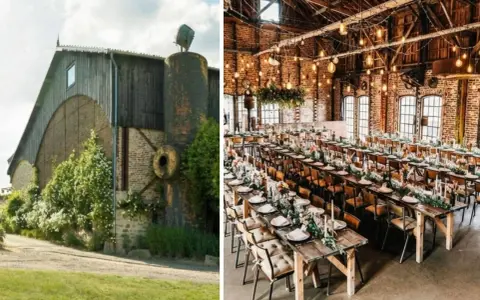 Un mariage insolite dans une grange aménagée, avec des tables dressées et décorées de fleurs, sous des guirlandes lumineuses.