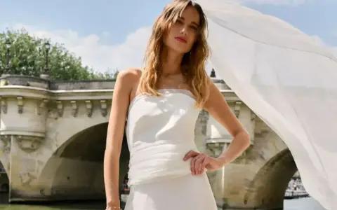 Robe de mariée aérienne signée Rime Arodaky, créatrice, sur un pont parisien.