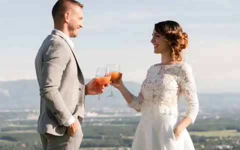 Un couple marié trinque avec des cocktails fruités, une belle quantité de soft pour un mariage en plein air.