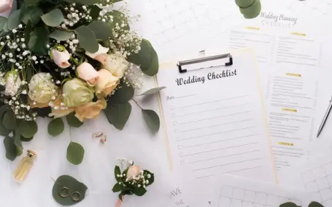 Un bouquet de roses, des alliances et une liste de mariage pour organiser son mariage soi-même.