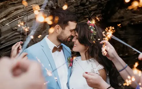Un couple s'embrasse tendrement, entouré de feux de Bengale, lors de leur entrée pour une cérémonie laïque joyeuse.