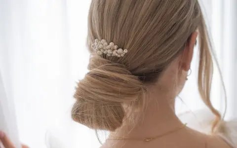 Chignon mariage flou orné d'un peigne de perles. Une coiffure élégante pour le grand jour.