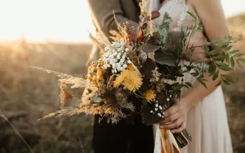Un bouquet champêtre aux tons chauds, parfait pour des cadeaux invités mariage fait maison. Des herbes de la pampa, des fleurs jaunes et des feuilles sombres.
