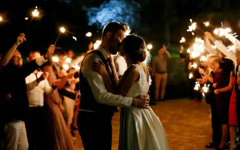 Un couple s'embrasse sous des feux de Bengale, entouré de leurs invités. Une belle idée d'animation mariage témoin pour un moment magique.