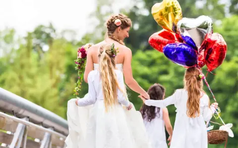 Mariée et enfants d'honneur, joyeux jeux d'enfants pour un mariage, avec des ballons en forme de cœur.