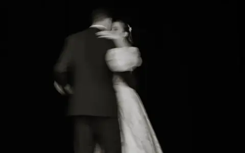 Un couple danse lors de l'ouverture de bal de leur mariage, le mouvement capturé dans un flou artistique.