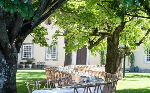 Table dressée dans un jardin luxuriant pour un quinta mariage Portugal. Ambiance champêtre sous les arbres.