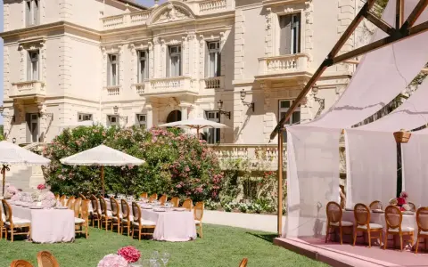Magnifique **organisation cérémonie laïque** dans un jardin, avec tables dressées et château en arrière-plan.