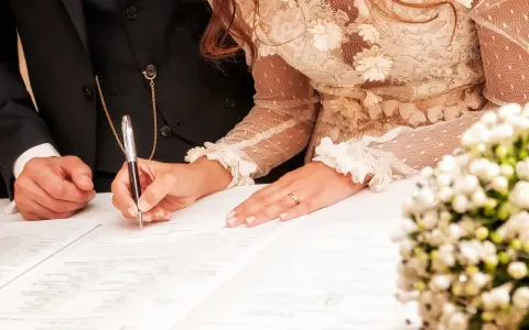 La mariée signe l'acte de mariage, un moment clé de la tradition mariage français. La bague au doigt symbolise leur union.