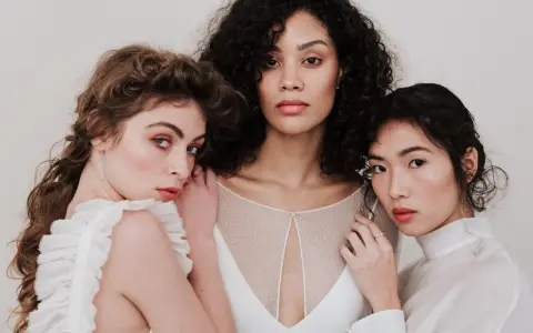 Trois femmes aux visages lumineux, prêtes pour un soin visage avant mariage. Leur peau est radieuse, leurs regards doux.