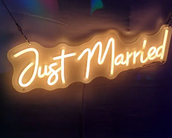 Néon "Just Married" illuminant, parfait pour une sortie de mariage dynamique, avec une musique entraînante.